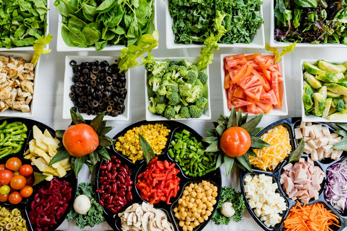 An assortment of fresh and leftover vegetables on a kitchen counter
